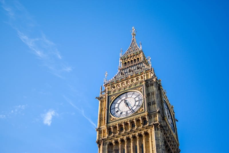 Big Ben clock tower in London against a clear blue sky.