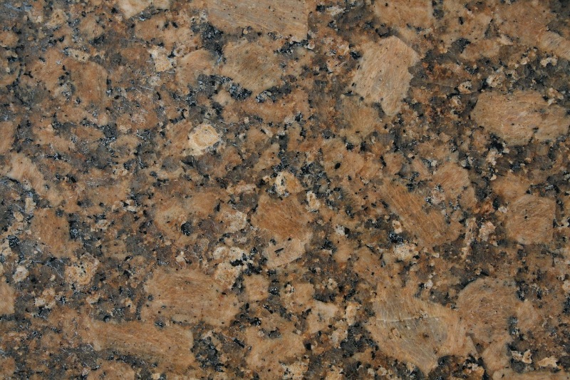 Close-up texture of polished brown granite stone.
