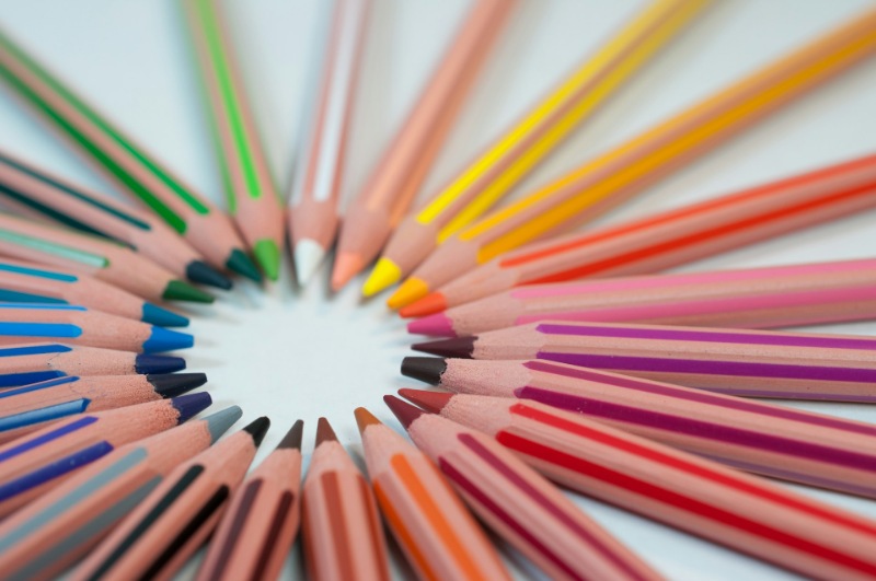 Close-up of colourful school pencils arranged in a circular pattern.