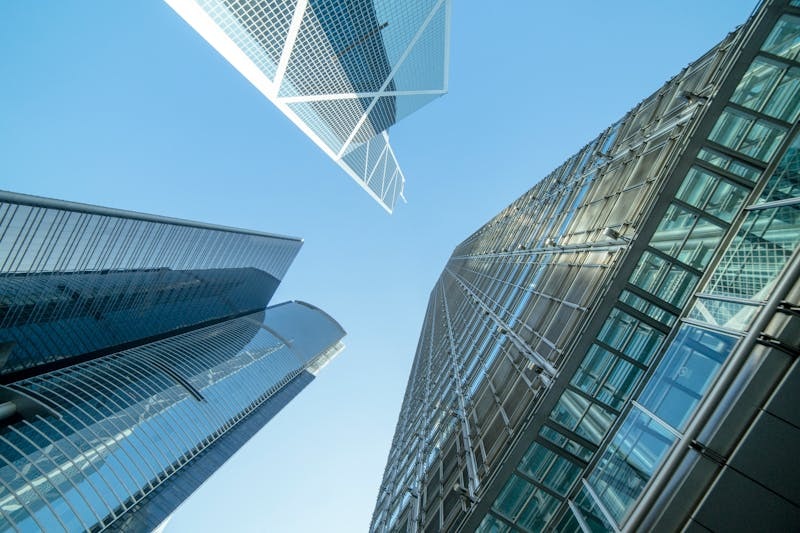 Modern glass-fronted commercial office building viewed from below.