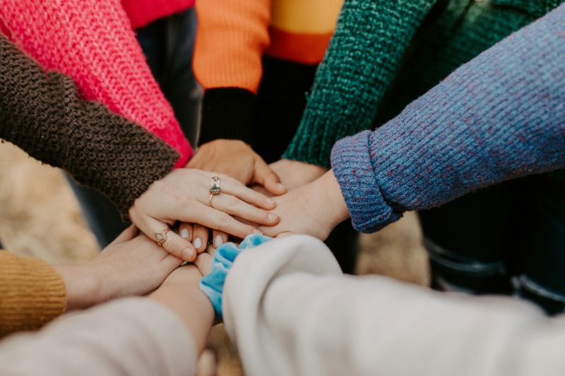 Group of hands stacked together symbolising teamwork and unity.