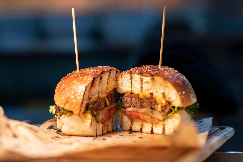 Close-up of freshly cooked burgers with melted cheese on a grill.