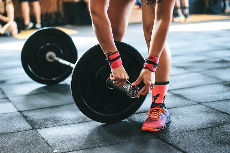 Athlete performing a barbell lift in a CrossFit gym.