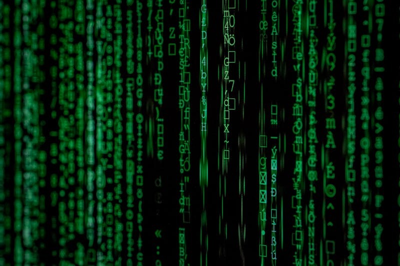 Digital background of green binary code on a black screen.