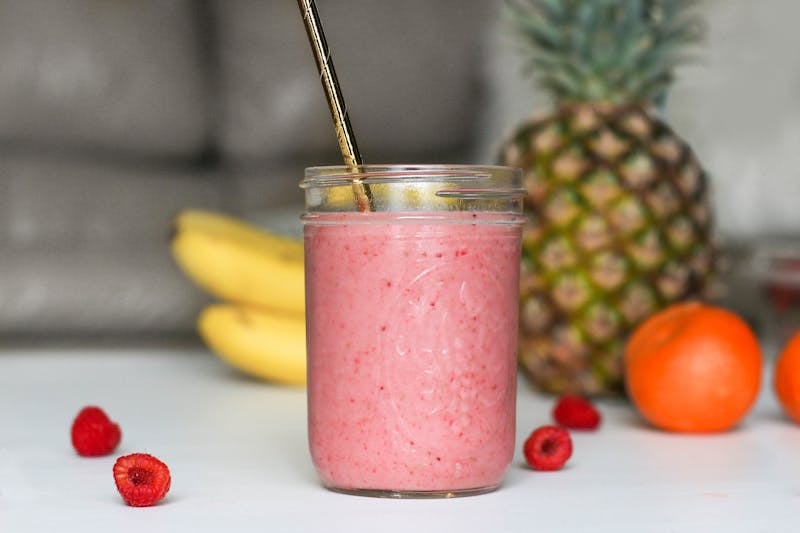 Glass of fresh fruit smoothie with pineapple and strawberries.
