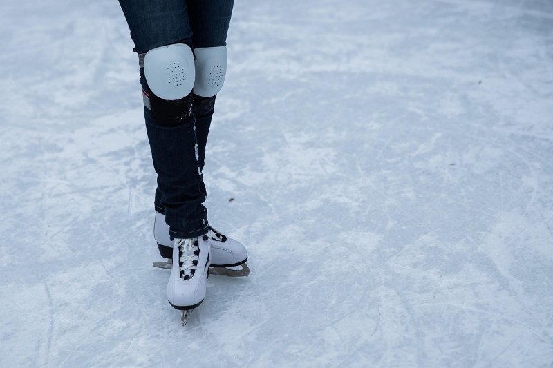 Person skating on an outdoor ice rink in winter.