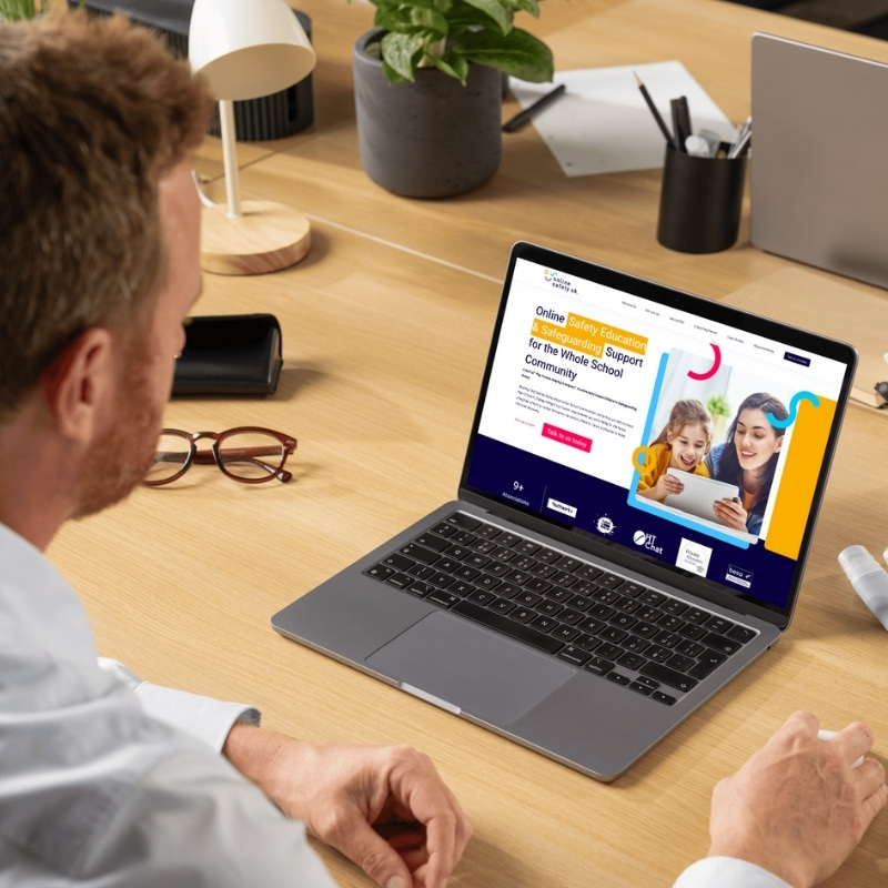 Laptop screen mockup featuring the Online Safety UK website design.