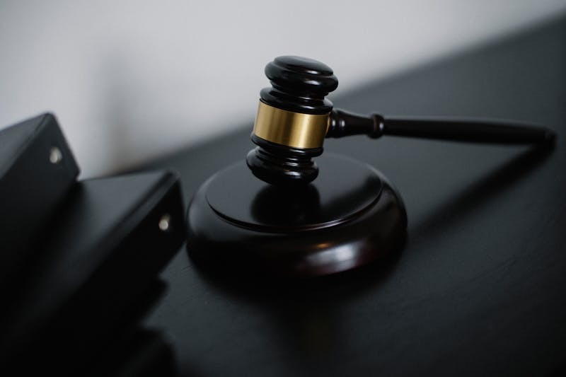 Barrister wearing a traditional wig and gown in a courtroom.