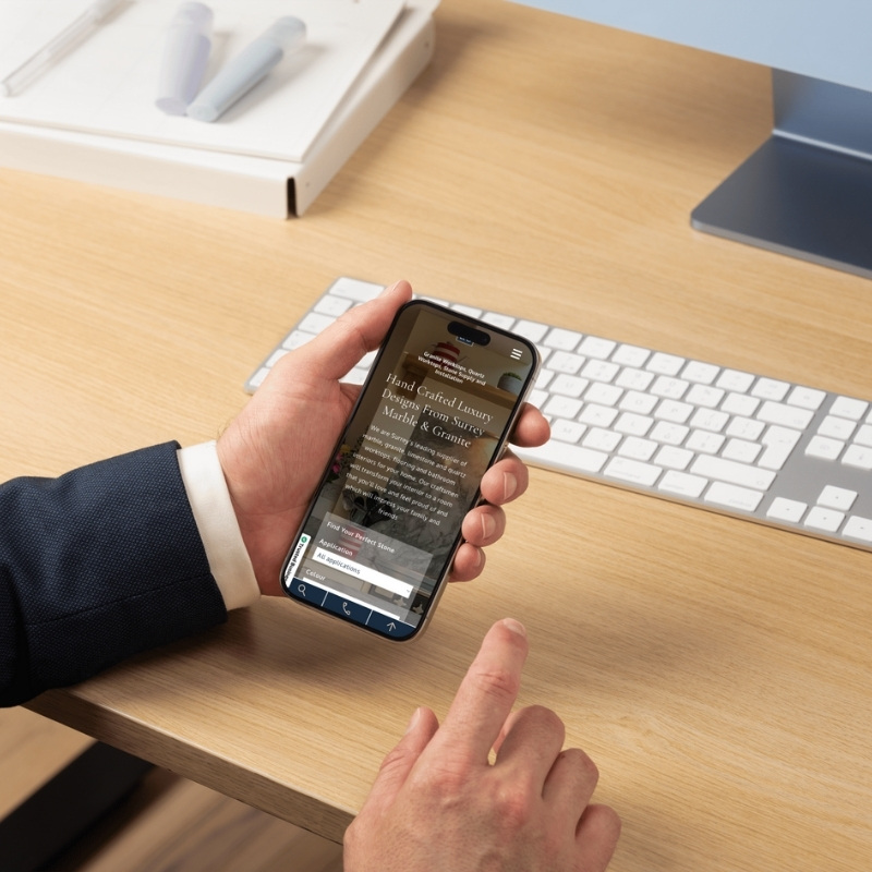 Mobile phone mockup displaying the Surrey Marble & Granite website homepage.