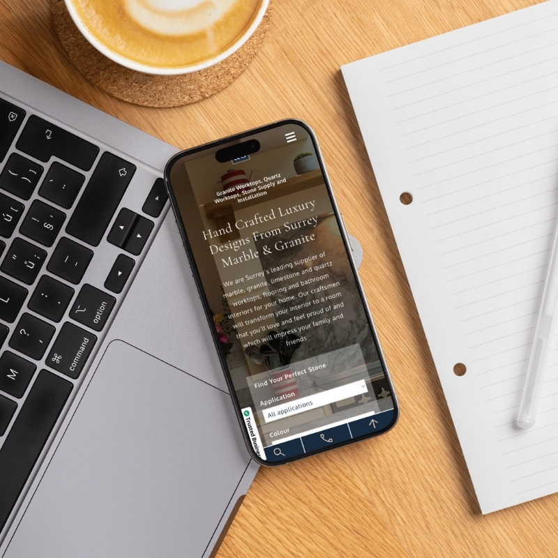 Smartphone screen mockup displaying the Surrey Marble & Granite website design.