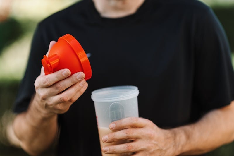 Person holding a protein shake bottle before a workout.