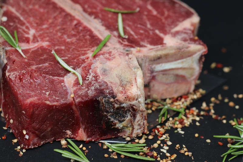 Fresh raw steak with marbled fat on a butcher’s board.