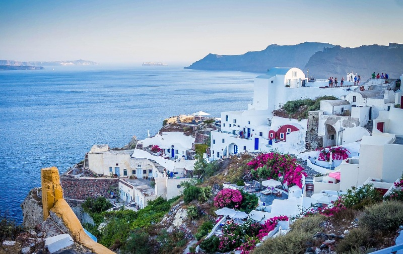Panoramic view of Santorini’s whitewashed buildings and blue domes.