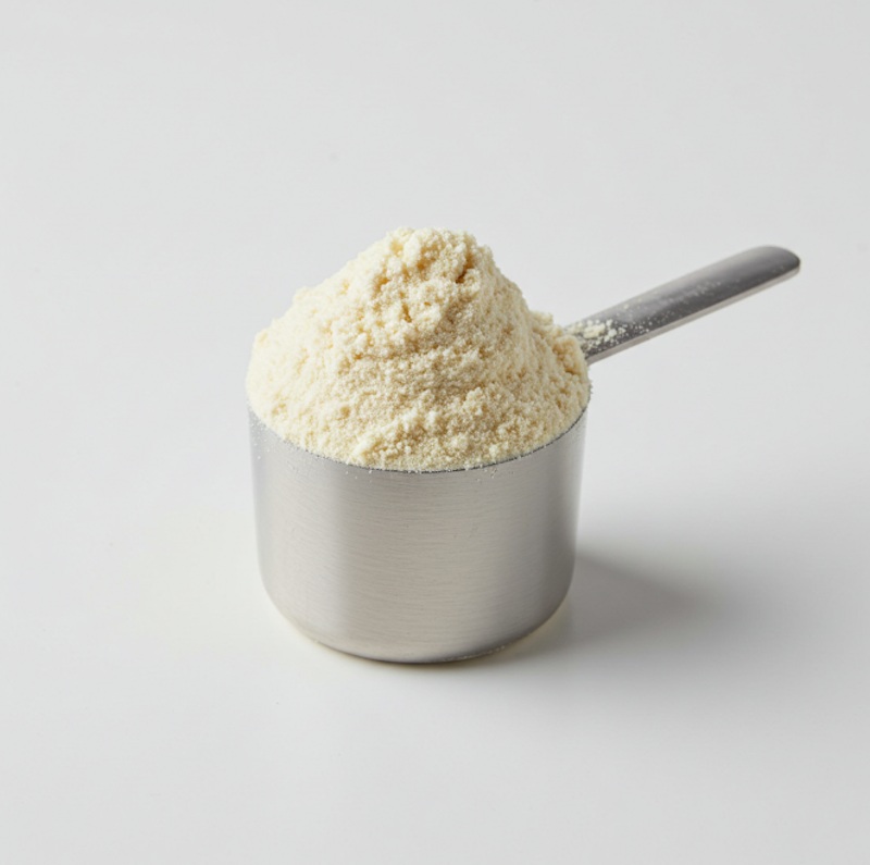 Scoop of white powdered nutritional supplement in a measuring spoon.