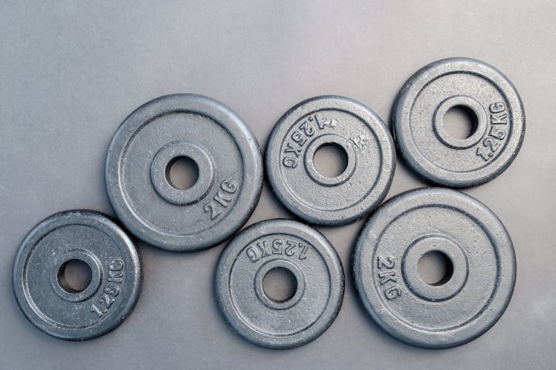 Close-up of stacked circular metal weight plates in a gym.