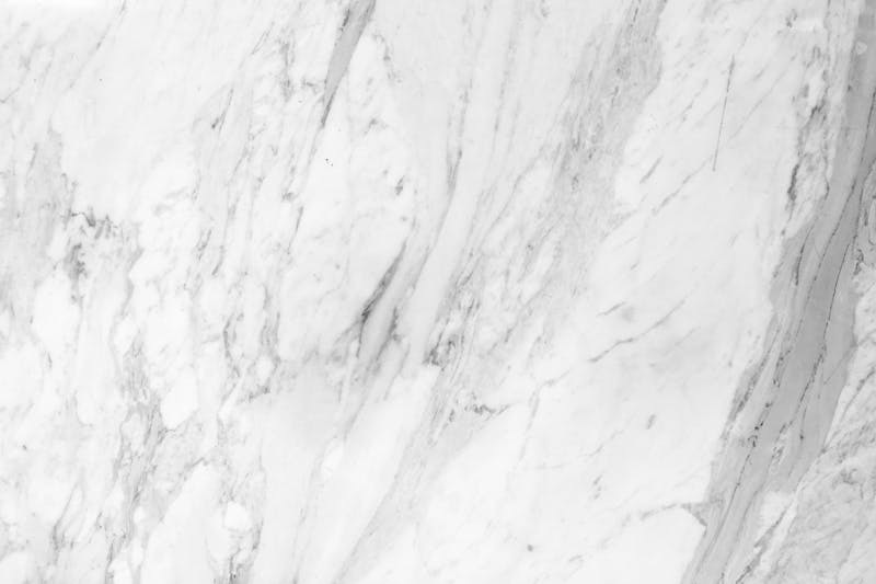 Detailed close-up of white marble with soft grey veining.