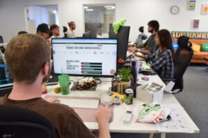 ai seo agency workers sat in front of their computers in an office